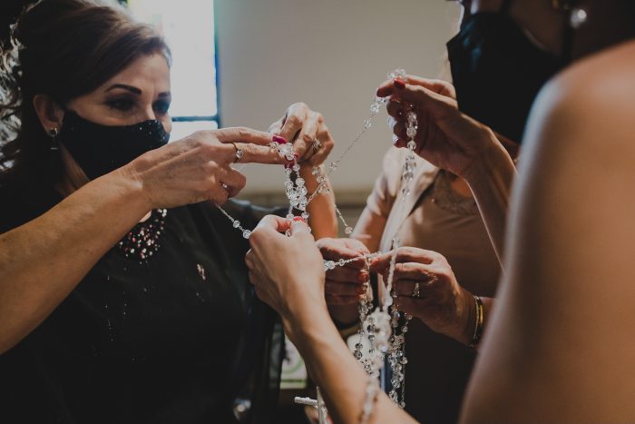 Tías desenredando el lazo de unión de boda religiosa